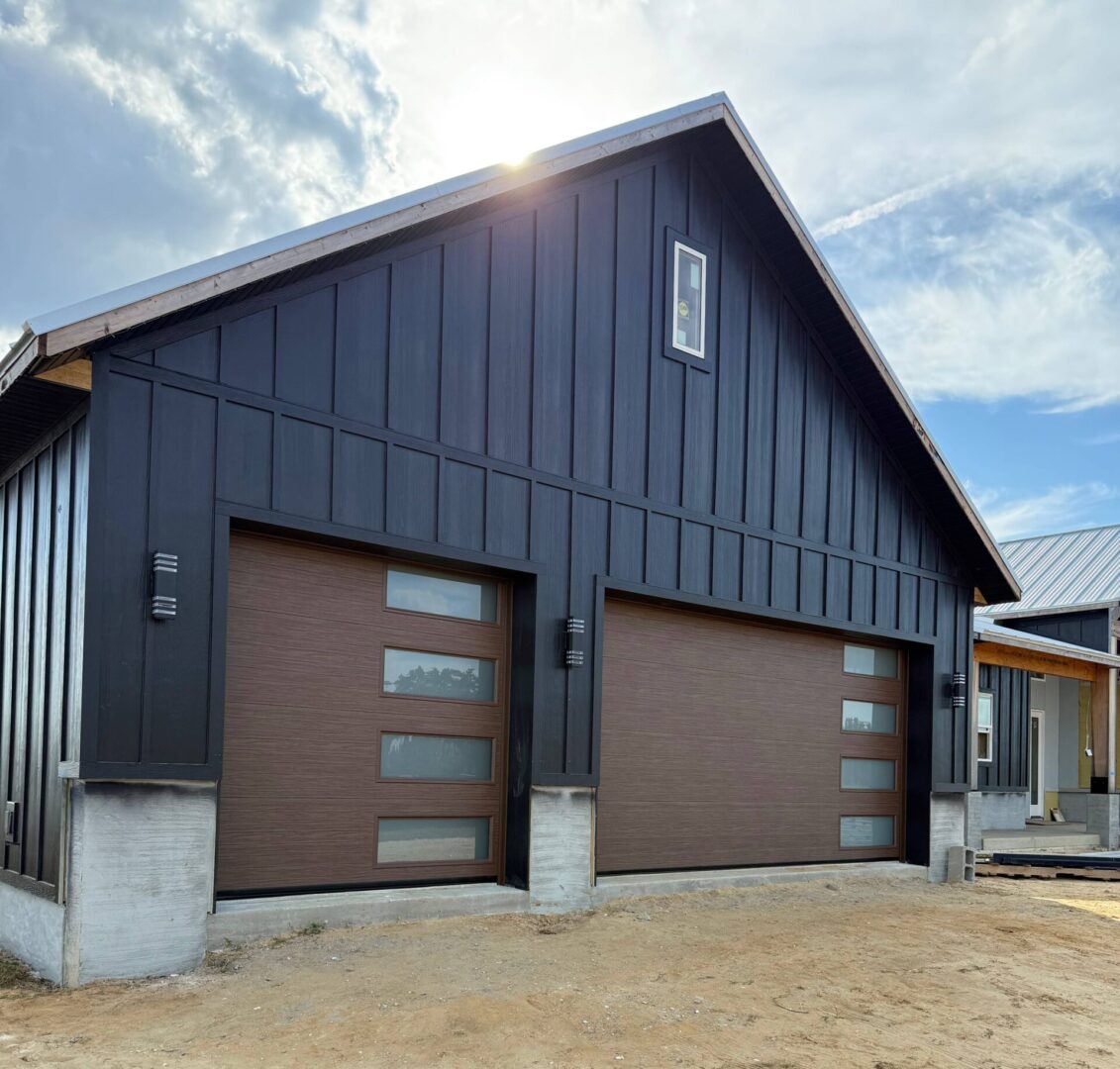Modern garage with two large doors under a blue sky.