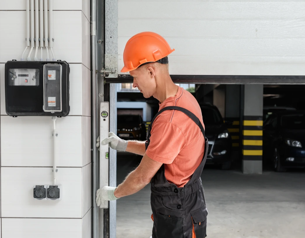 Worker repairing garage door mechanism